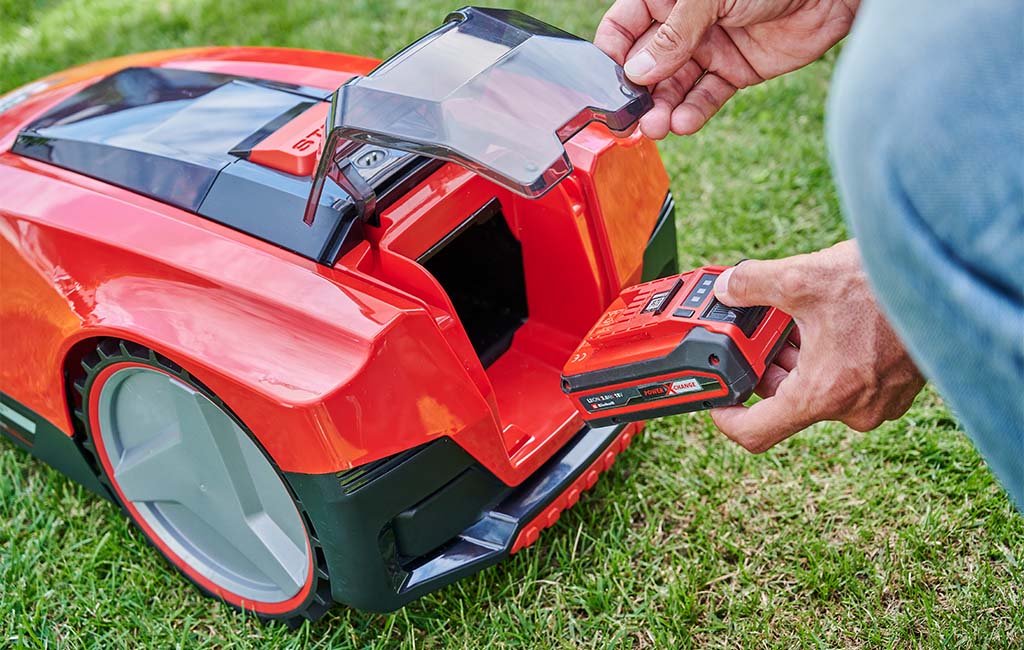 A battery is inserted into a robotic lawnmower.