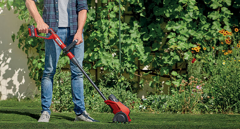 man using surface brush in garden