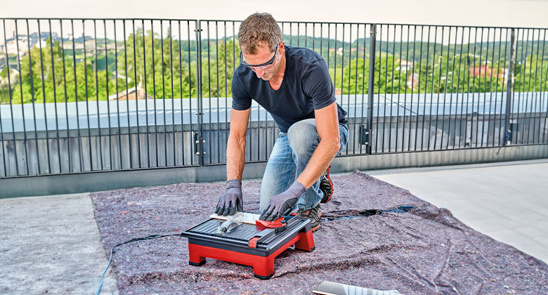 a man is using the Einhell cordless tile cutting machine